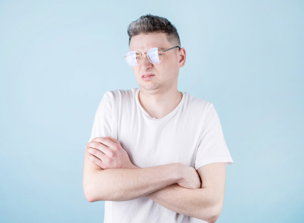 蓝色背景下的年轻人脸上露出厌恶的表情。消极情绪面部表情。图片下载