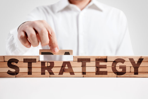 商人用战略这个词搭建了一个木块结构。图片下载