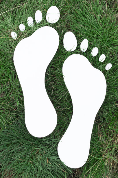 纸做的脚印铺在绿草上图片下载