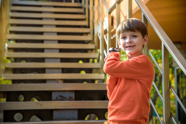 小男孩看智能手表的照片。儿童和现代科技。孩子放学后打电话给他的朋友或父母图片下载