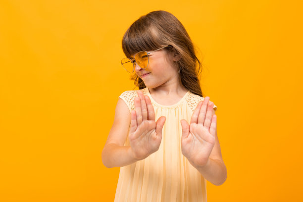 美丽的小女孩穿着衣服孤立在黄色或橙色的背景图片下载