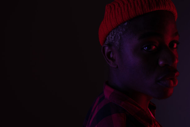 特写的时尚帅气的黑人男子在霓虹灯下的阴影图片下载