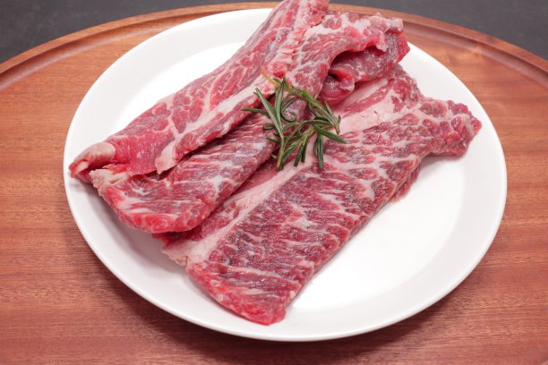 新鲜的生肉放在白色的盘子里图片下载