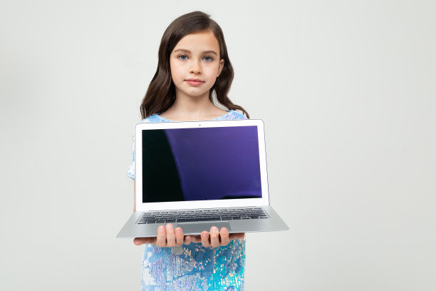 十几岁的女孩拿着一个空白屏幕的笔记本电脑插入一个网站在一个白色的工作室背景图片下载