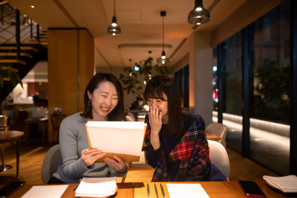 快乐的女性朋友在餐馆看菜单图片下载