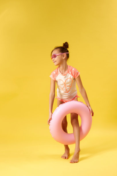 小女孩穿着泳衣，戴着充气橡胶圈图片下载