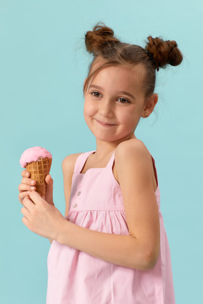 可爱的小女孩在吃华夫筒香草冰淇淋图片下载