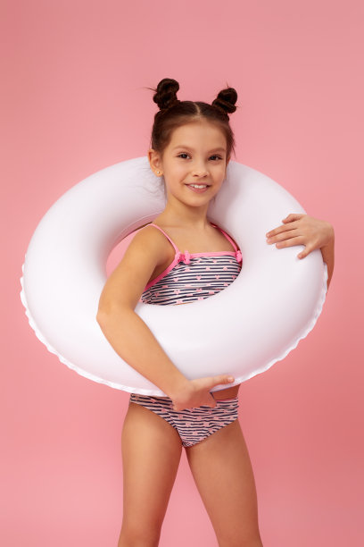 穿着泳衣的小女孩带着充气橡胶圈图片下载