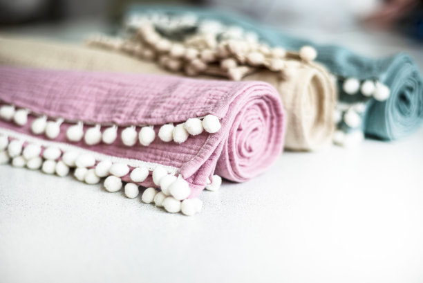 带装饰辫子的多色平纹毛巾卷。家用纺织品用有机棉。为文本复制空间。图片下载