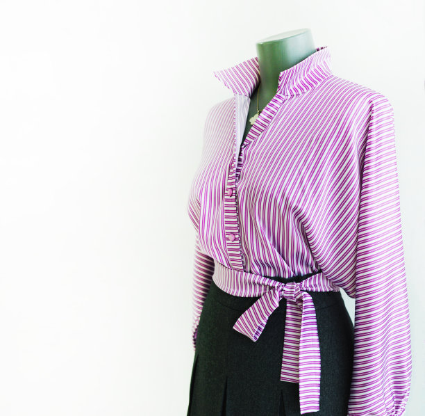 模特身上穿着一件带领口和缎带的紫色条纹丝质衬衫。为文本复制空间。图片下载