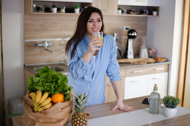 漂亮的女人拿着杯子与美味的果汁库存照片图片下载