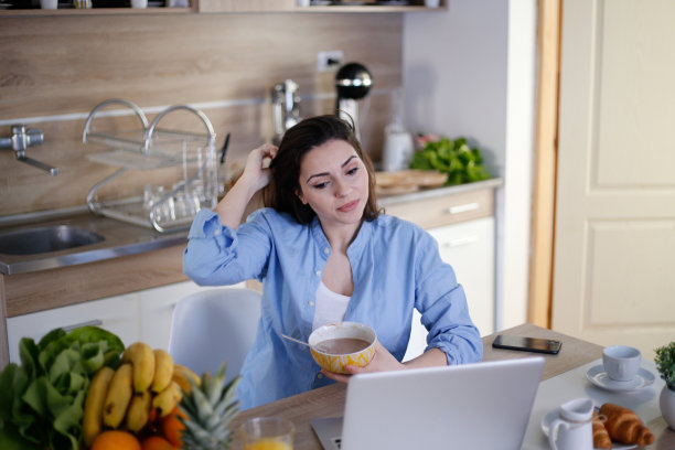 美丽的年轻女子坐在办公桌在一个办公室和吃午餐库存照片图片下载