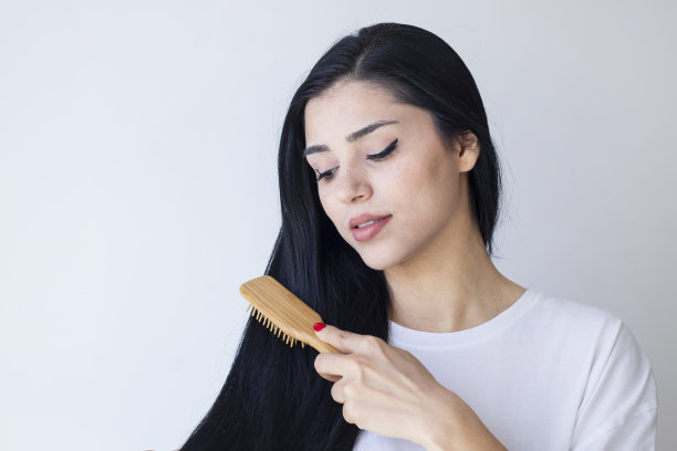 孤立的肖像一个美丽的年轻女子梳长发图片下载