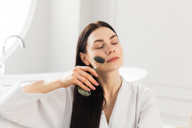 美丽的欧洲女人用玉滚轮按摩她的脸图片下载