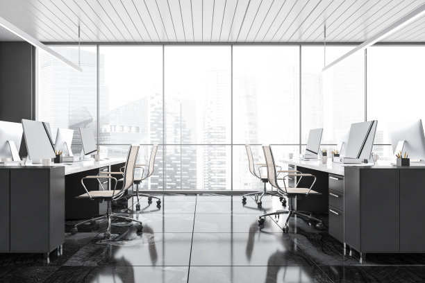 有扶手椅和电脑的灰色办公室，靠近摩天大楼的窗户图片下载