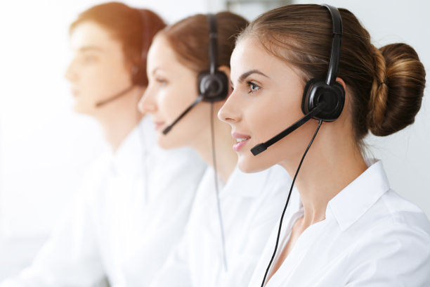 呼叫中心。美丽的年轻女子使用耳机和电脑帮助客户在阳光明媚的办公室。经营理念图片下载