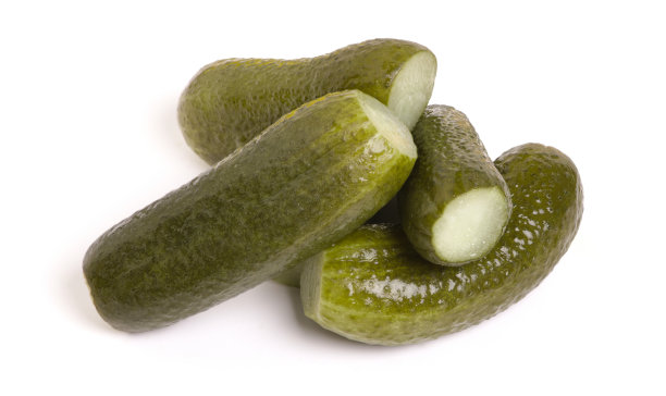 白色背景上的四根腌黄瓜。图片下载