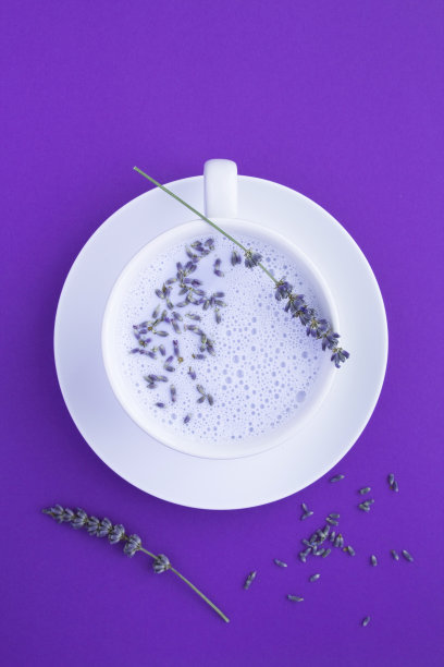 俯视图薰衣草月亮牛奶在白色的杯子在紫罗兰的背景图片下载