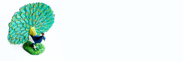 白色背景上的孔雀玩具。横幅图片下载
