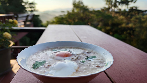 夏天森林山中央的大米粥，配猪肉鸡肉和香菜叶煮鸡蛋，广告民宿图片下载