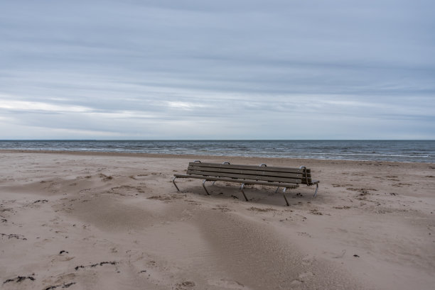冬天的一天，在海风吹拂的波罗的海海岸海滩上的空长凳图片下载