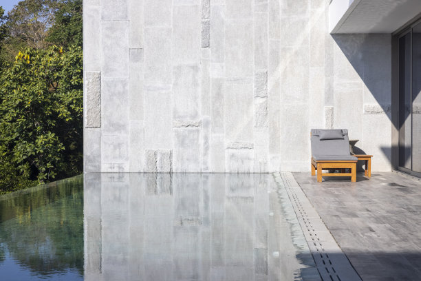 在泰国的波吉度假胜地，一张木椅坐在泳池边。给你一种放松的感觉。关于度假、旅游、自然、景观、健康的概念图片下载