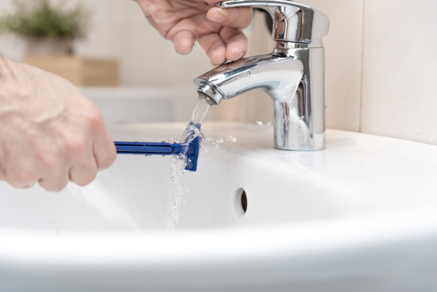 男人刮胡子时洗剃须刀图片下载