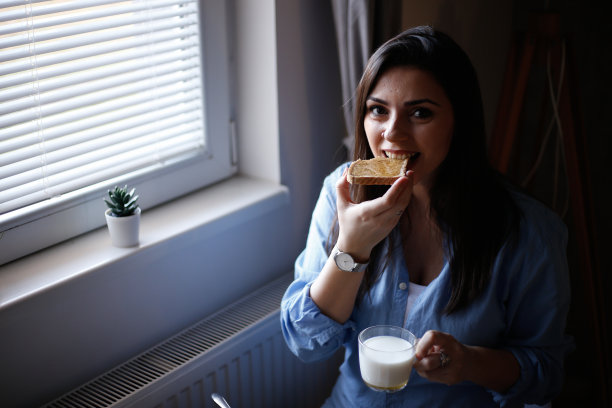 女人在烤面包上吃蜂蜜的照片图片下载