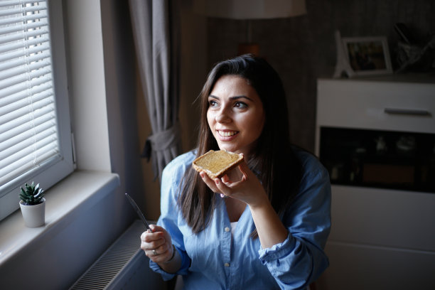 女人在烤面包上吃蜂蜜的照片图片下载