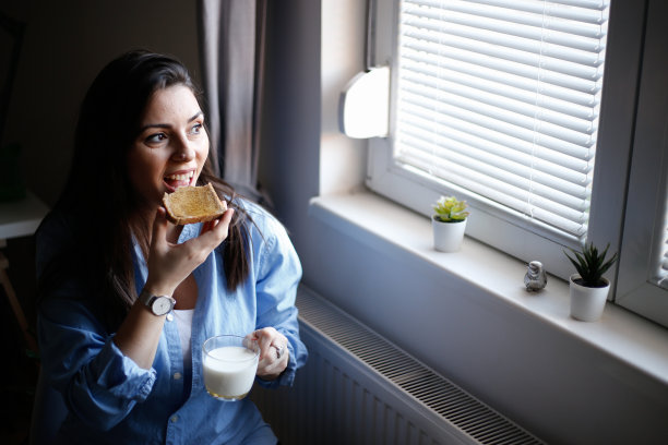 女人在烤面包上吃蜂蜜的照片图片下载