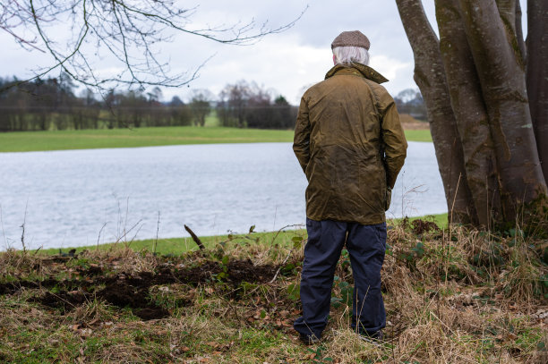 后视图的农民看一个被淹没的田地图片下载