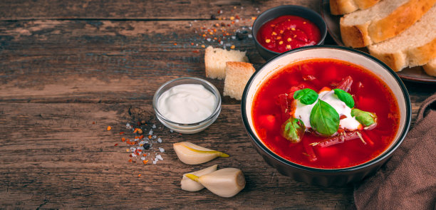 甜菜根汤特写，大蒜，酸奶油和罗勒在木制的棕色背景图片下载