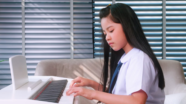 一个小女孩打算在家练习弹钢琴。图片下载