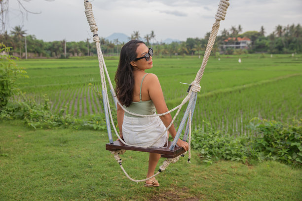 印度尼西亚游客坐在巴厘岛的木制秋千上图片下载