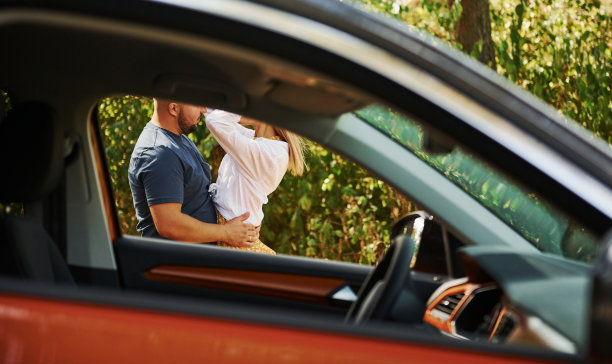 一对情侣在现代汽车附近的森林里拥抱对方图片下载