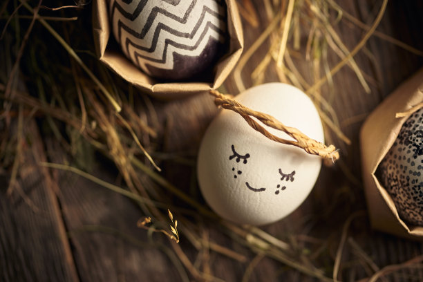 可爱的复活节彩蛋天使躺在木质的干草表面上，特写。基督教的宗教节日图片下载