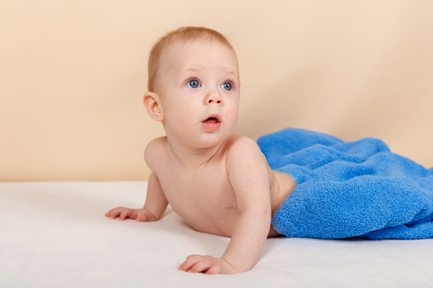 有趣的小男孩洗澡后在床上放松和微笑图片下载