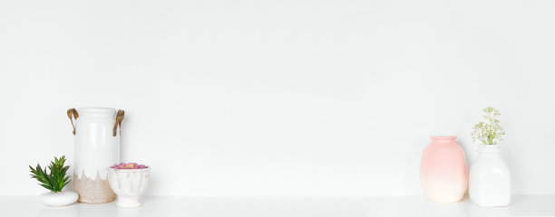 架子上的家居装饰。现代花瓶，多肉植物和鲜花。白色的架子靠着白色的墙。图片下载