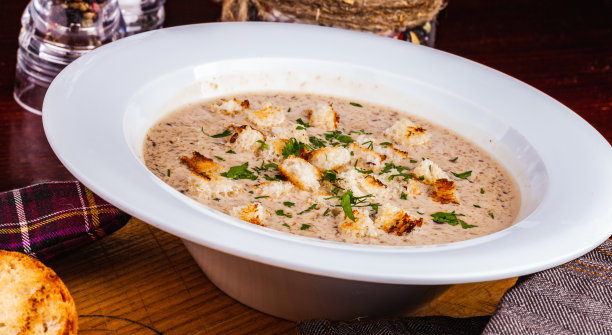蘑菇奶油汤与面包丁在白色盘子图片下载