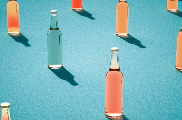 几只淡蓝色背景上有阴影的啤酒瓶。图片下载