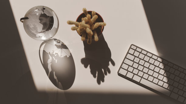 办公桌，键盘，仙人掌和地球仪的裁剪镜头。彩色的照片。图片下载