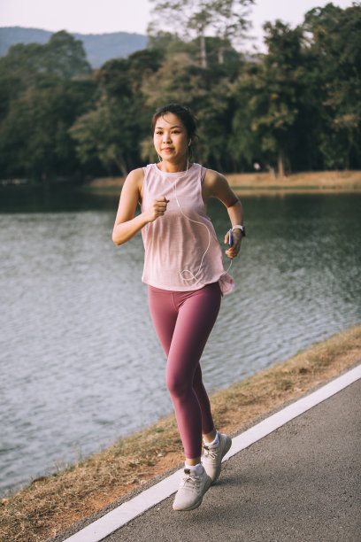 亚洲女人在公园慢跑-存货照片图片下载