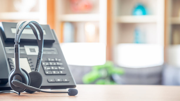近距离软聚焦耳机与电话设备在办公桌客户服务支持。图片下载