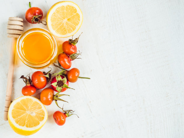 新鲜的黄柠檬，一壶蜂蜜和红浆果图片下载