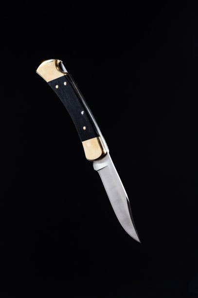 狩猎折叠刀与黄金口音。经典的猎刀。图片下载