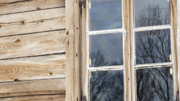 用木板把房子的旧木墙上的窗户封起来。雕刻装饰着旧窗户。形象设计。农村的概念。图片下载