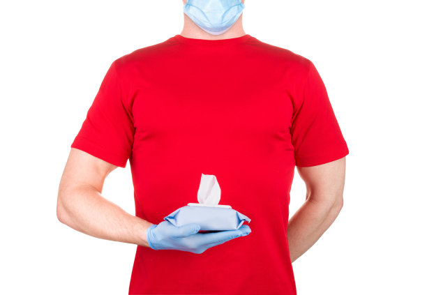 身穿红色t恤、戴医用口罩和手套、手持湿巾或纸巾的男子被隔离图片下载