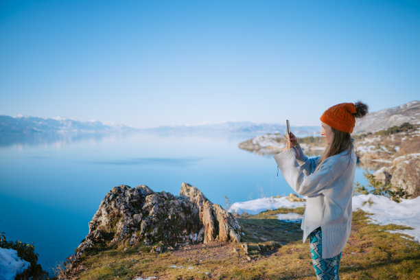 年轻女子用智能手机拍湖图片下载