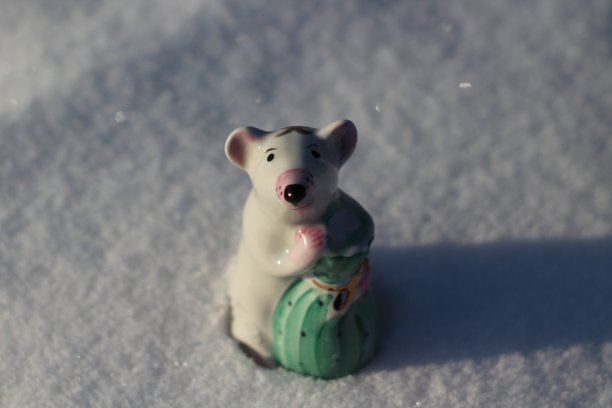《冬雪小瓷人》中的农历鼠象。可爱的小老鼠雕像，拿着装满财富和健康的袋子图片下载