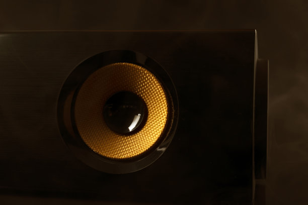 在黑暗的背景下，黄色音频扬声器的特写。图片下载